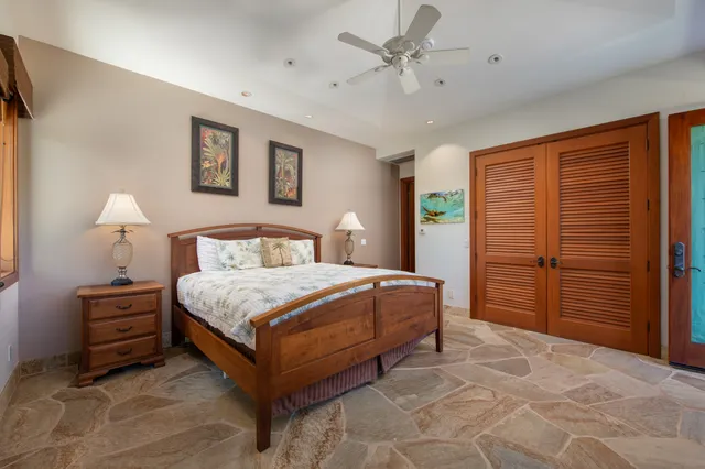 a spacious bedroom with a bed and a chandelier