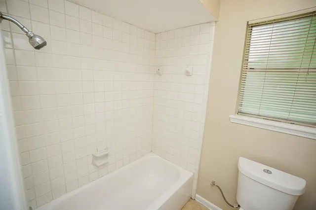 a bath room with a toilet a sink and a bath tub