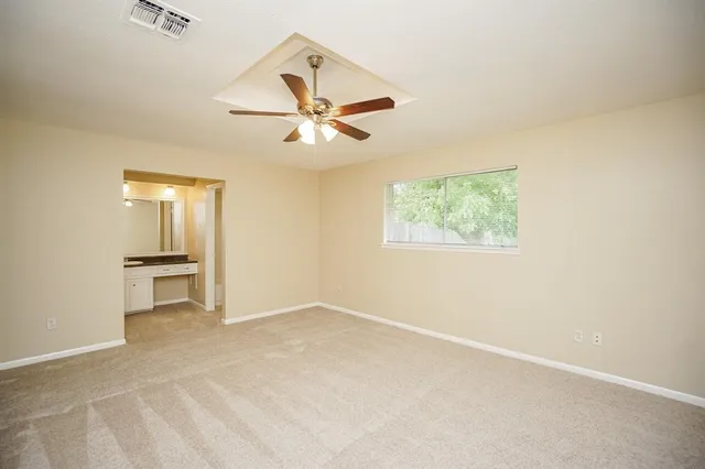 an empty room with a window and a ceiling fan