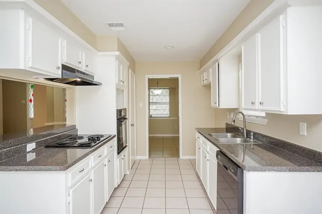 a kitchen with granite countertop white cabinets and white appliances