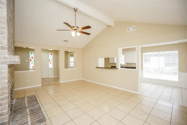 a view of empty room with fireplace and fan