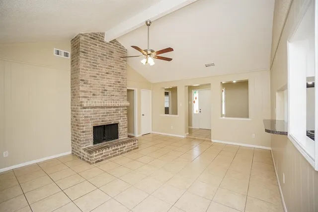 a view of a livingroom with a fireplace and a chandelier fan
