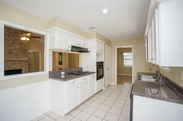 a kitchen with granite countertop a sink and a stove top oven