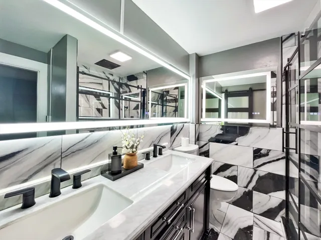 a kitchen with a sink dishwasher and a refrigerator with a large mirror