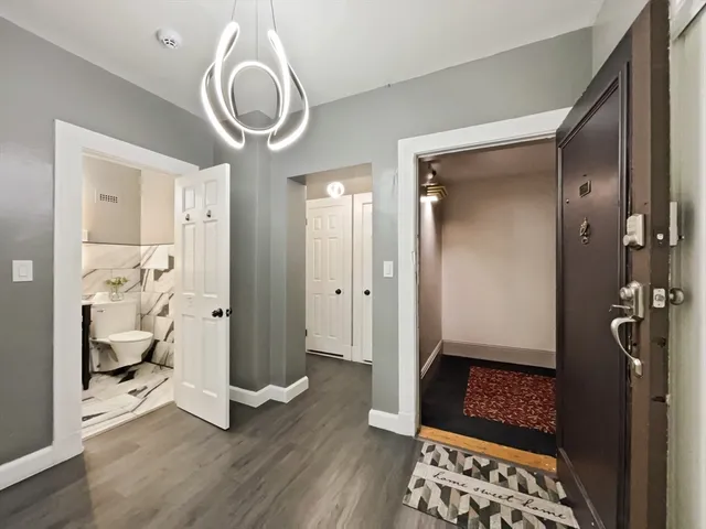 a room with wooden floor and a chandelier