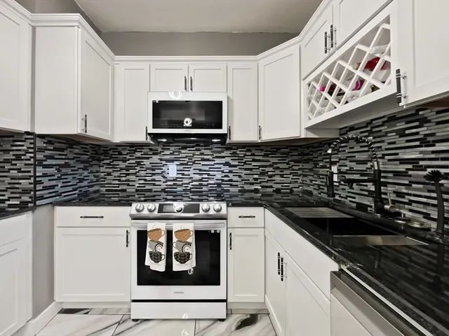 a kitchen with stainless steel appliances a stove and a microwave
