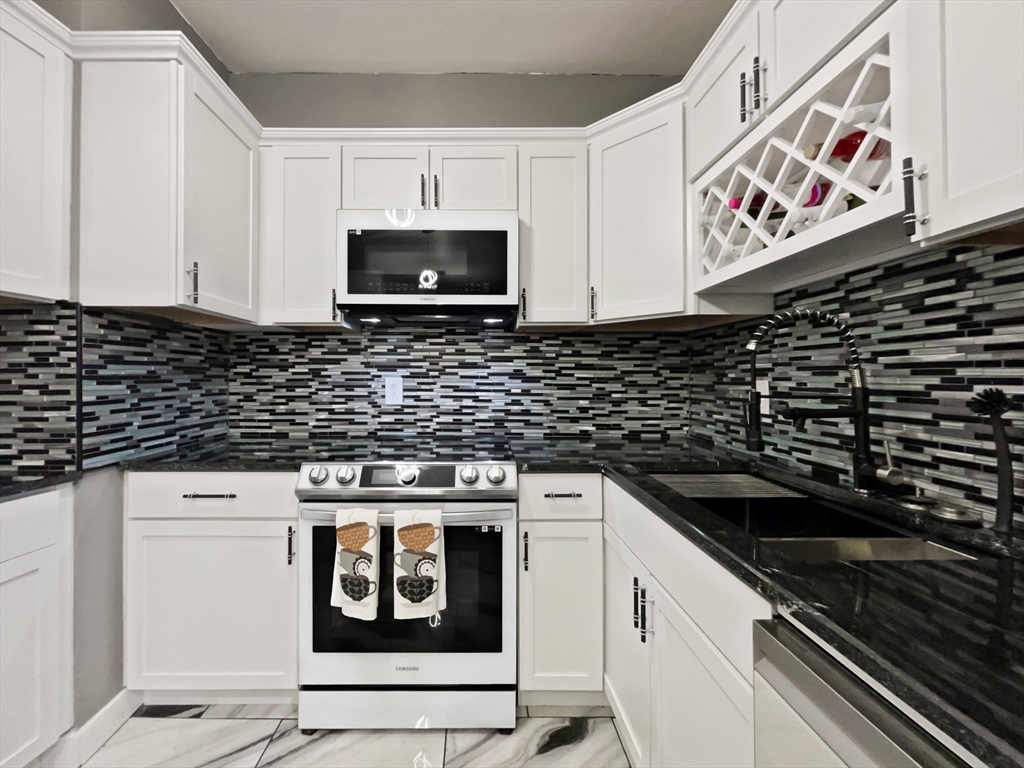 140 Chestnut Street, Unit 706 Springfield, MA 01103 - Photo 2 of 23 a kitchen with stainless steel appliances a stove and a microwave