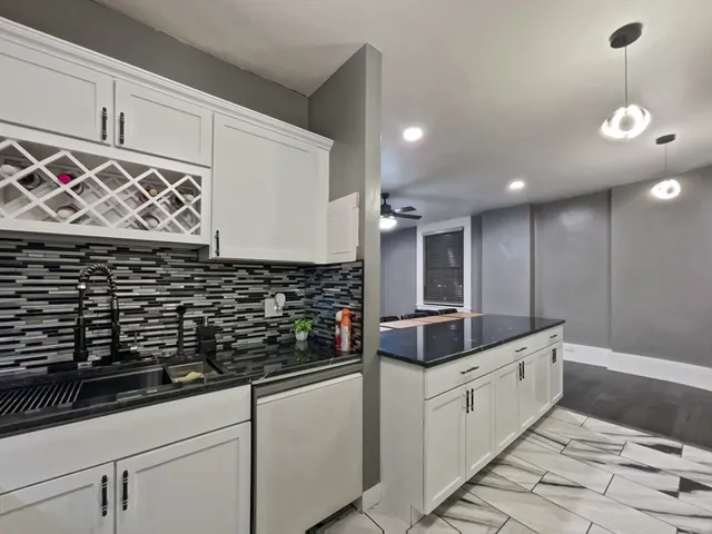 a kitchen with white cabinets and sink