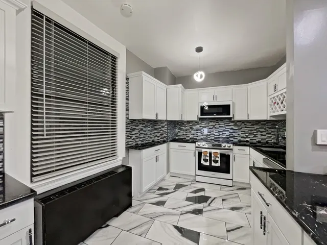 a kitchen with granite countertop a sink and a stove top oven