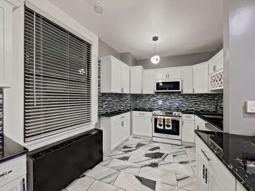 140 Chestnut Street, Unit 706 Springfield, MA 01103 - Photo 5 of 23 a kitchen with granite countertop a sink and a stove top oven