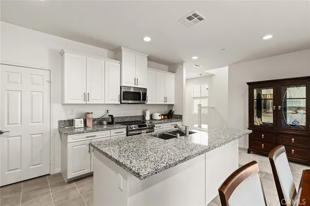 a kitchen with stainless steel appliances granite countertop a sink stove and cabinets