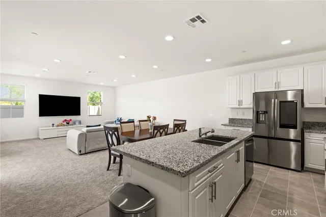 a kitchen with stainless steel appliances granite countertop a sink and a refrigerator