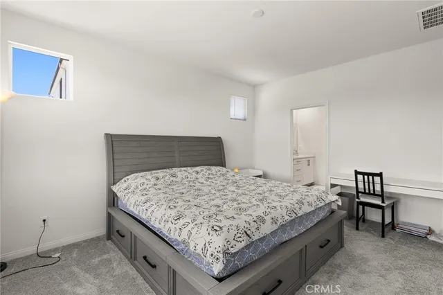 a bedroom with a bed and a stool