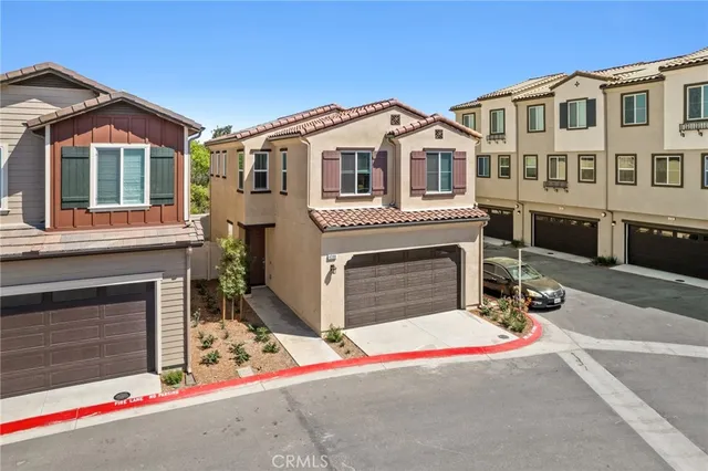 a view of a white house with large windows and a small yard
