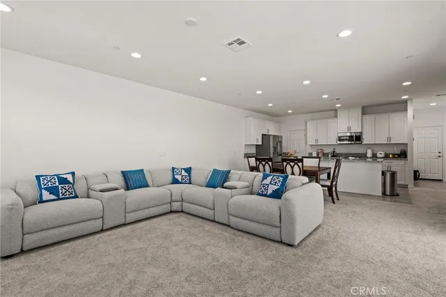 a living room with furniture and a kitchen view
