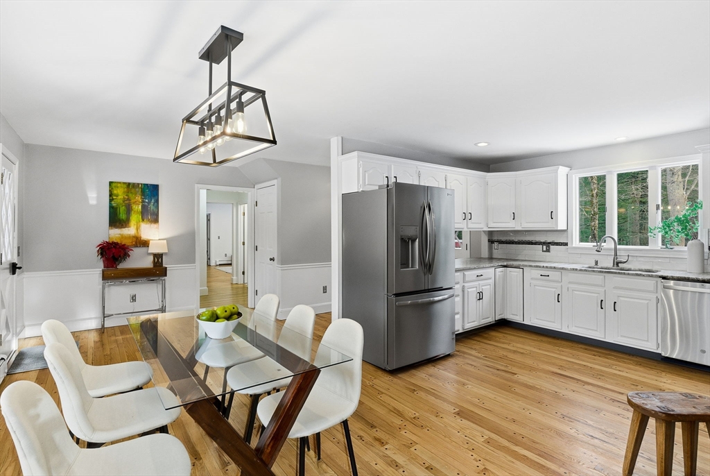 75 Barre Road Hubbardston, MA 01452 - Photo 15 of 42 a kitchen with stainless steel appliances kitchen island granite countertop a refrigerator a stove a sink dishwasher a dining table and chairs with wooden floor