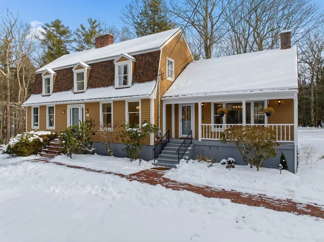 a front view of a house with a yard and potted plants