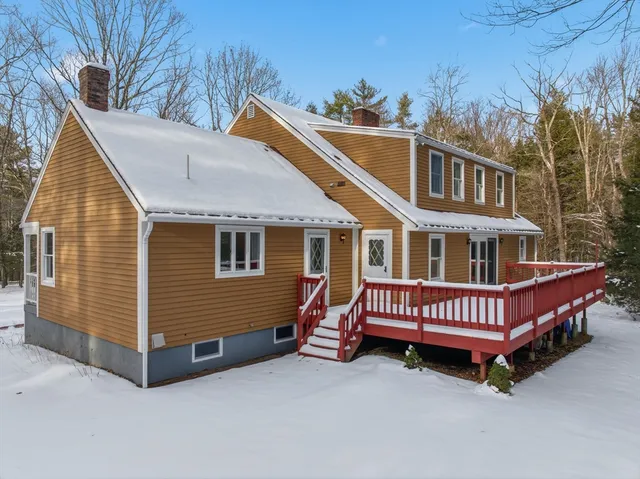 a view of a house with a yard and wooden deck