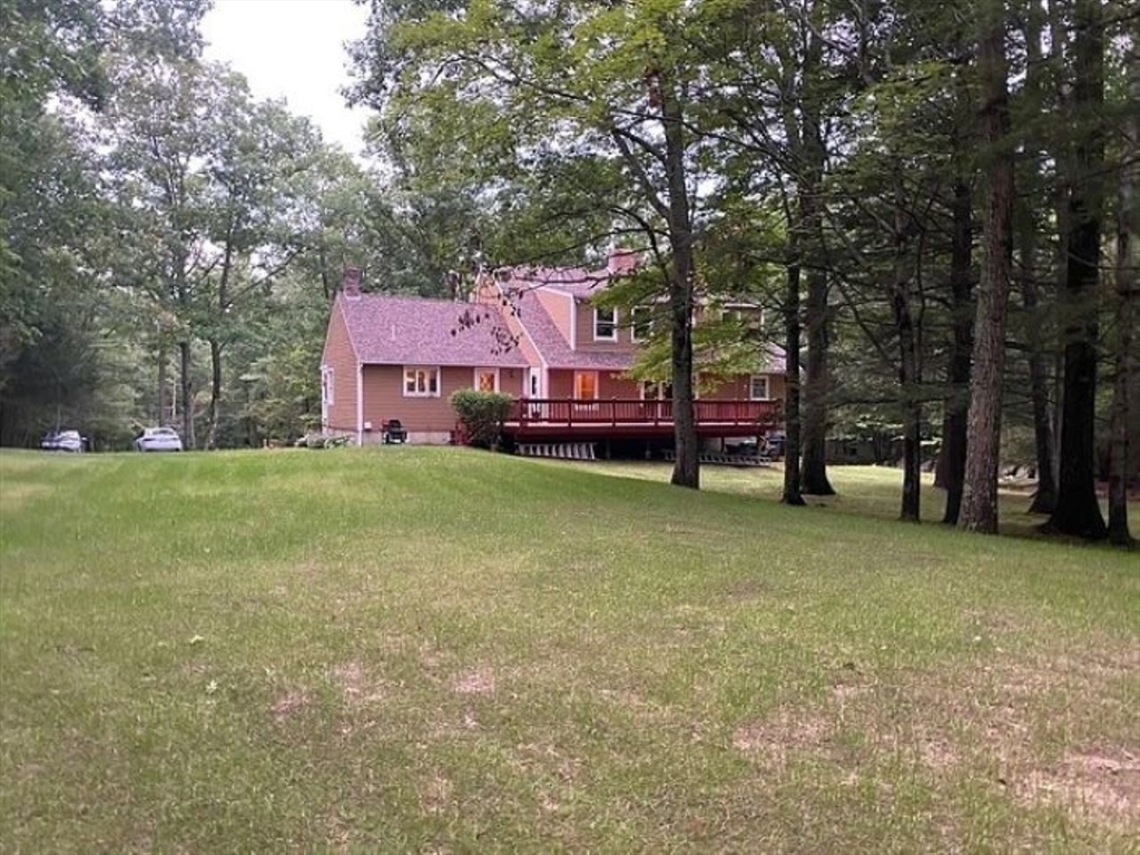 75 Barre Road Hubbardston, MA 01452 - Photo 7 of 42 a front view of a house with a garden and tree