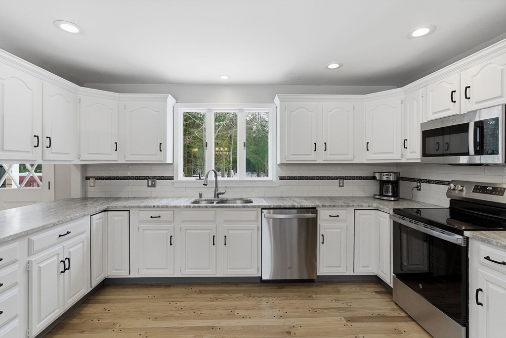 75 Barre Road Hubbardston, MA 01452 - Photo 8 of 42 a kitchen with white cabinets stainless steel appliances and sink