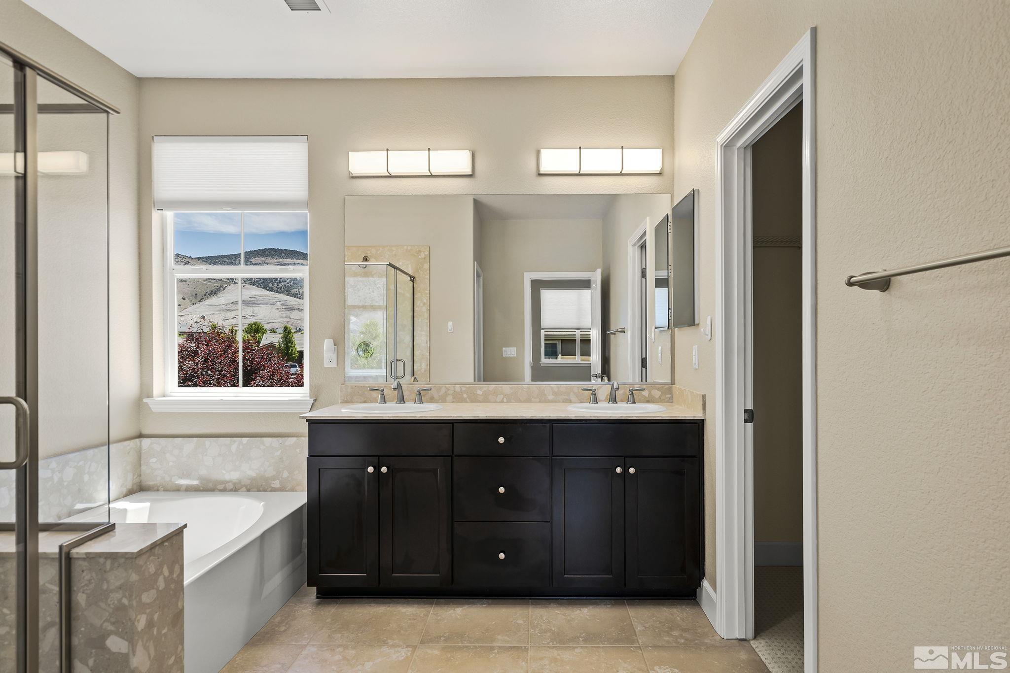 10819 Walnut Ridge Drive Reno, NV 89521 - Photo 13 of 22 a spacious bathroom with a double vanity sink a large mirror and a bathtub