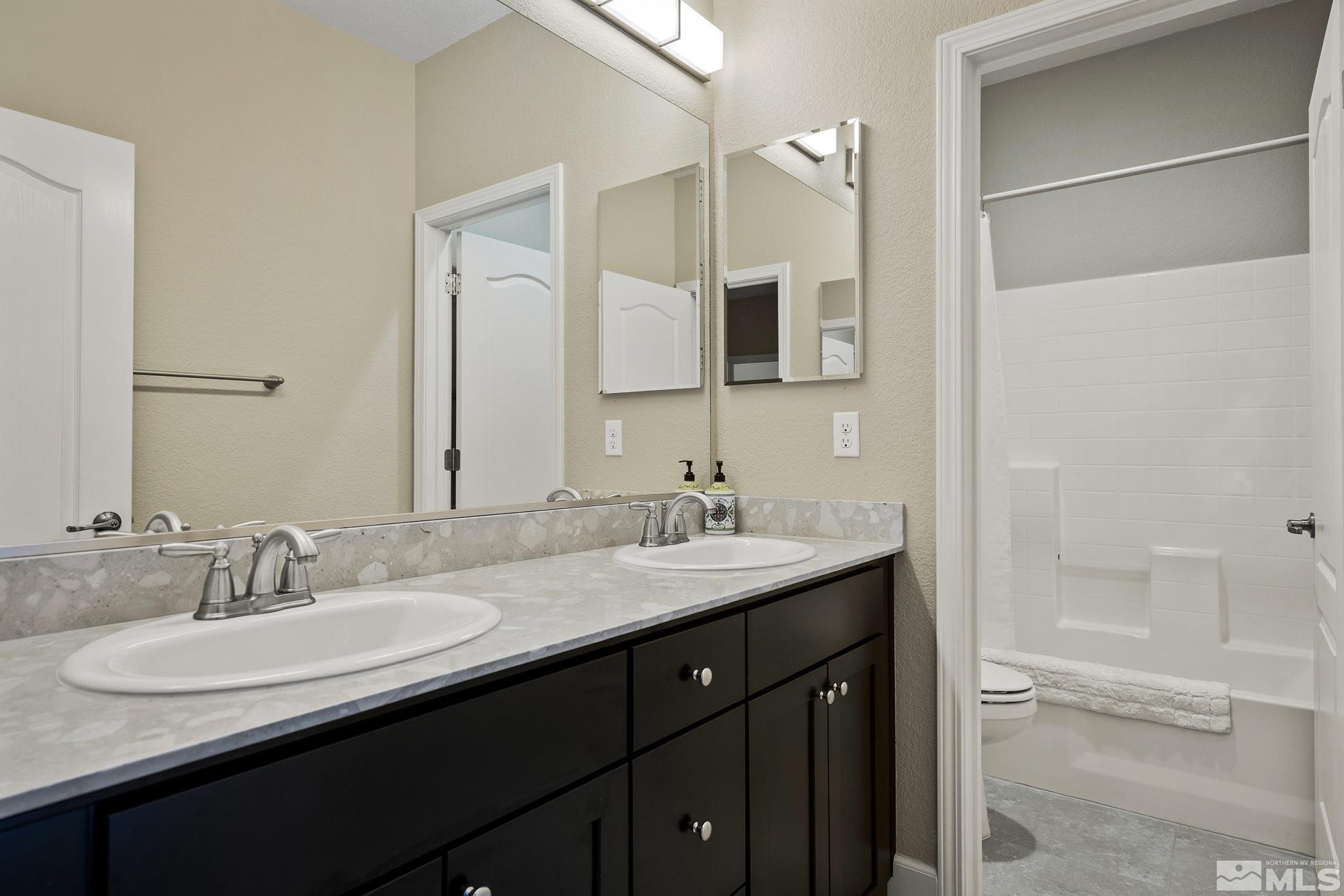 10819 Walnut Ridge Drive Reno, NV 89521 - Photo 18 of 22 a bathroom with a granite countertop sink and a mirror
