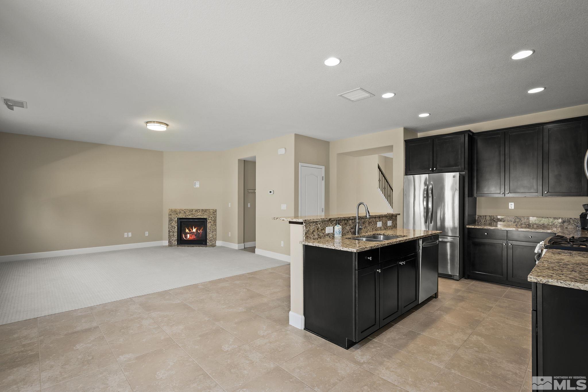 10819 Walnut Ridge Drive Reno, NV 89521 - Photo 2 of 22 a kitchen with kitchen island a sink stove and refrigerator