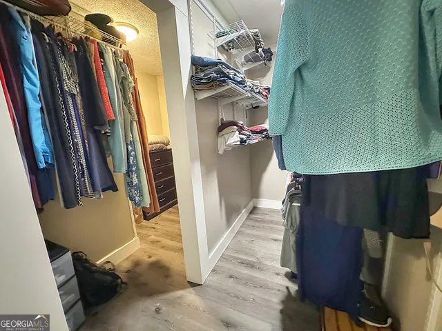 a view of walk in closet with clothes and shoes