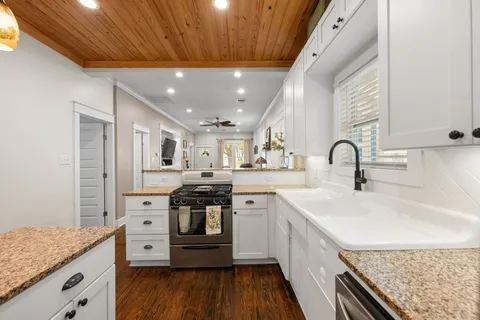 a kitchen with stainless steel appliances granite countertop a sink stove and cabinets