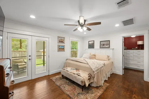 a bedroom with a bed a chandelier and a window