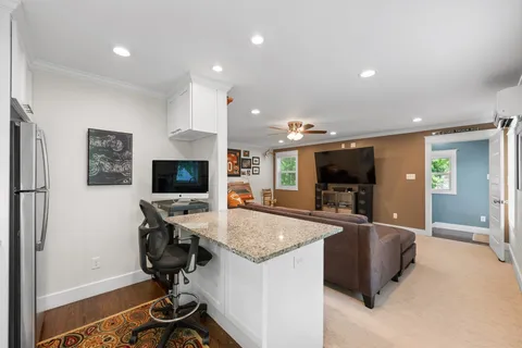 a view of a living room a flat screen tv and a refrigerator
