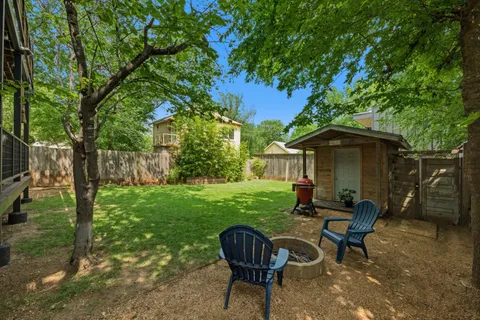 a view of a chair and table in backyard of the house