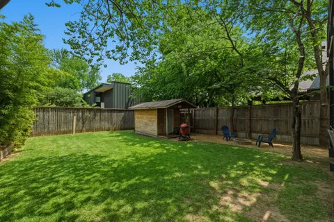 a backyard of a house with table and chairs