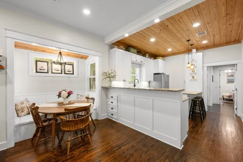 a kitchen with a dining table chairs and wooden floor