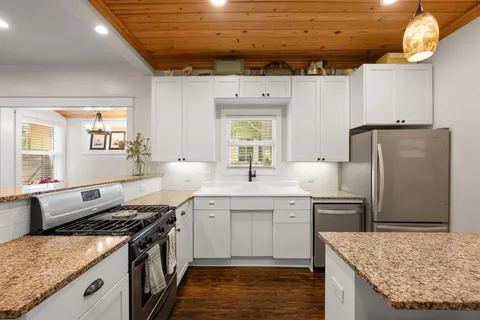 a kitchen with stainless steel appliances granite countertop a sink stove and refrigerator