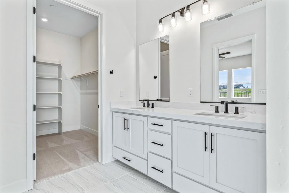 14838 Grace Warren Way Rancho Murieta, CA 95683 - Photo 15 of 22 a bathroom with double sink and a mirror