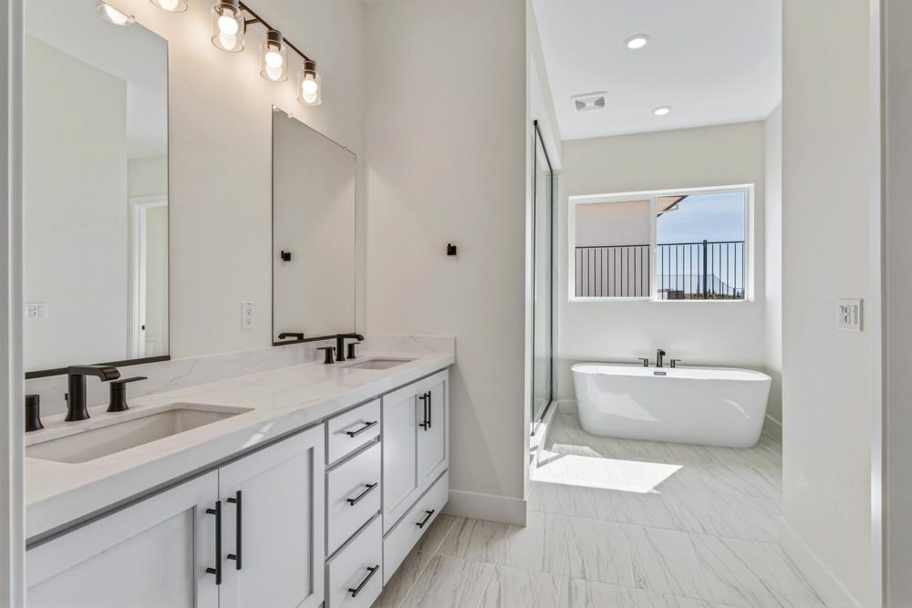 14838 Grace Warren Way Rancho Murieta, CA 95683 - Photo 15 of 18 a spacious bathroom with a double vanity sink double mirror and bathtub