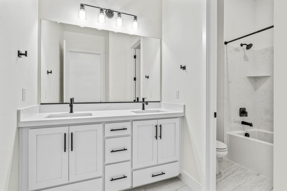 14838 Grace Warren Way Rancho Murieta, CA 95683 - Photo 20 of 22 a bathroom with a granite countertop sink a toilet and shower