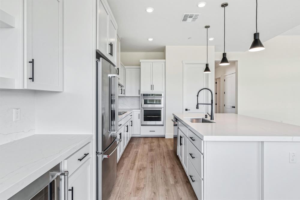 14838 Grace Warren Way Rancho Murieta, CA 95683 - Photo 6 of 18 a kitchen with kitchen island a sink stove and refrigerator