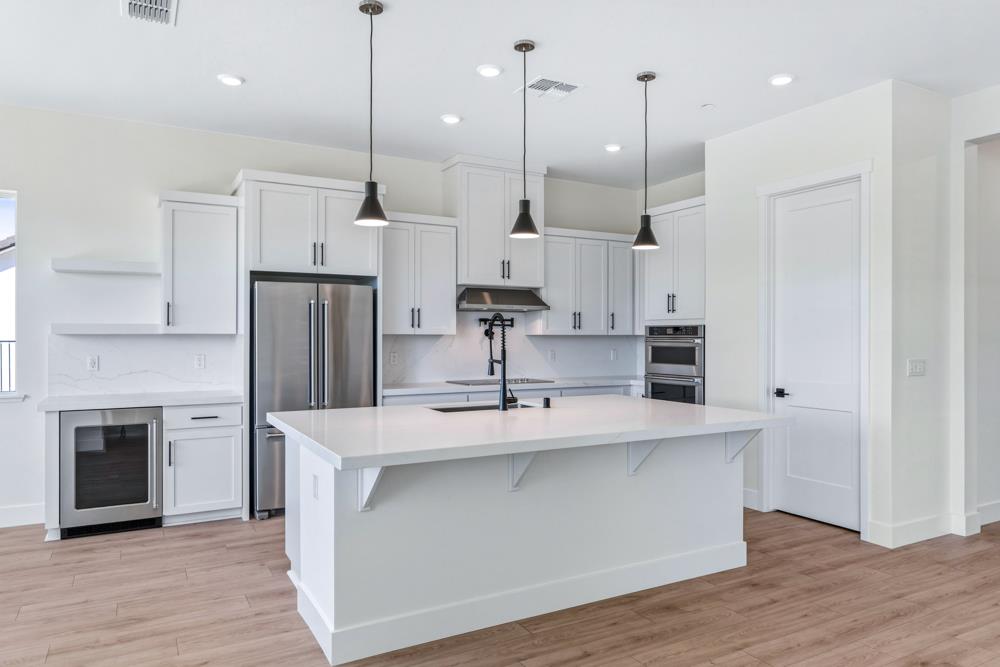 14838 Grace Warren Way Rancho Murieta, CA 95683 - Photo 10 of 18 a kitchen with kitchen island a counter top space a sink and appliances