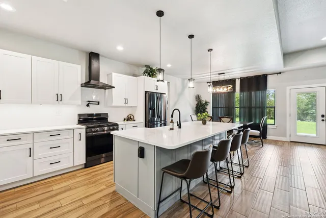 a kitchen with stainless steel appliances granite countertop a sink refrigerator and cabinets