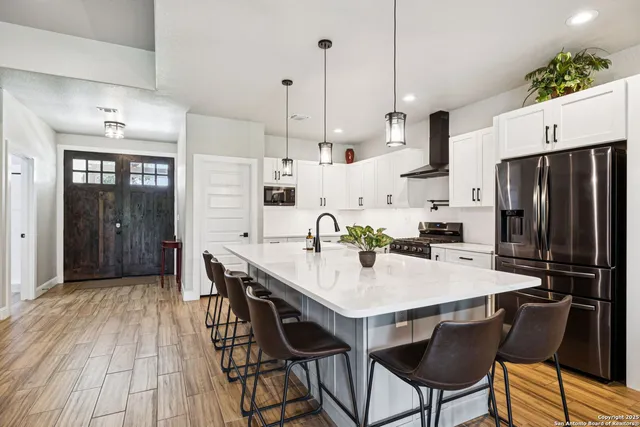 a kitchen with stainless steel appliances a stove and white cabinets