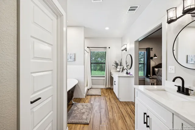 a bedroom with a bed a window and a flat screen tv