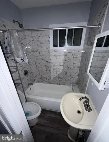 a bathroom with a sink a toilet and bathtub