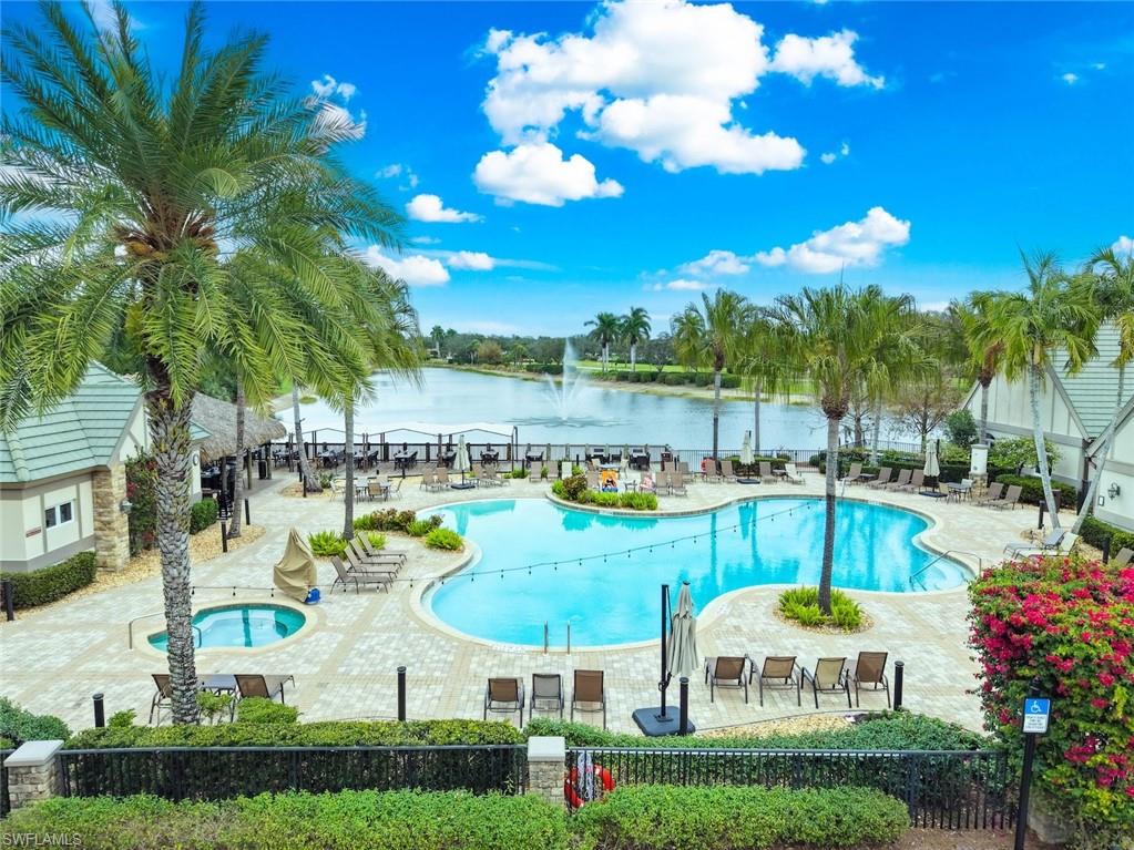 12692 Kinross Lane Naples, FL 34120 - Photo 38 of 47 Twin Eagles Country Club's expansive resort-style pool with a separate spa, paver deck, and lush landscaping, featuring a picturesque lake with a fountain