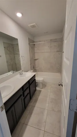 a bathroom with a double vanity sink a mirror and a bathtub