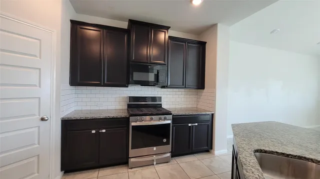 a kitchen with stainless steel appliances granite countertop a stove and a microwave