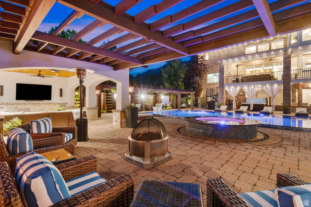 12308 Mariah Circle Draper, UT 84020 - Photo 137 of 293 Expansive paver patio featuring a built-in outdoor kitchen with a large screen, a recessed fire pit, and a swimming pool