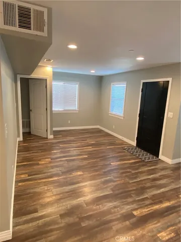 a view of a livingroom with wooden floor and a ceiling fan