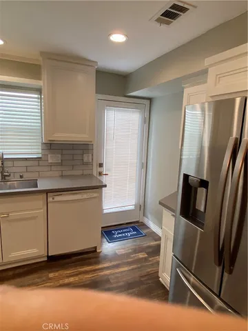 a kitchen with granite countertop a refrigerator and a sink
